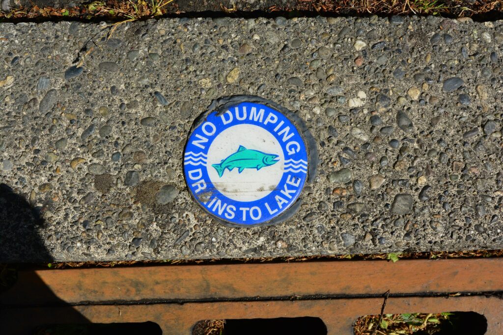 Storm drain marker reading No Dumping, Drains to Lake on the University of Washington campus in Seattle